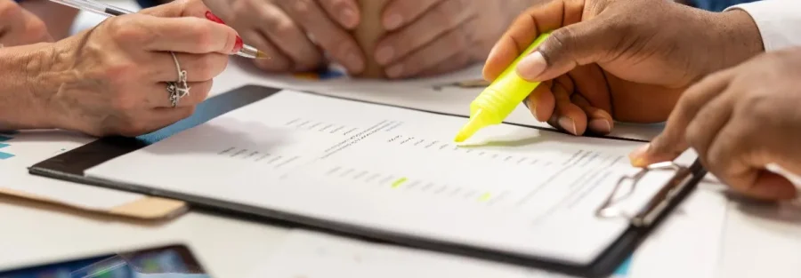 Business professionals reviewing documents during a meeting for IT Annual Maintenance Contract Services in Abu Dhabi.