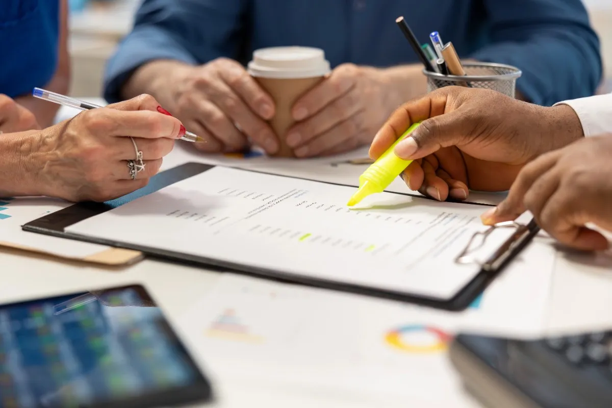 Business professionals reviewing documents during a meeting for IT Annual Maintenance Contract Services in Abu Dhabi.