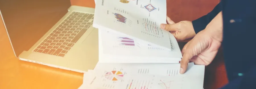 Business professionals reviewing quotations, reports, and analytics on a laptop using quotation management software solutions in Abu Dhabi to improve sales efficiency.