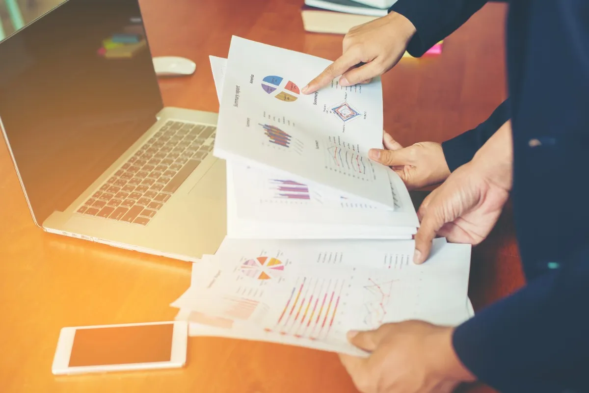 Business professionals reviewing quotations, reports, and analytics on a laptop using quotation management software solutions in Abu Dhabi to improve sales efficiency.